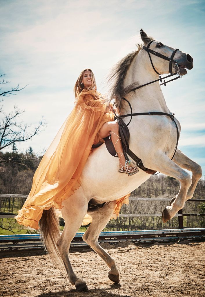 Elsa Pataky wearing a long dress whilst on her horse