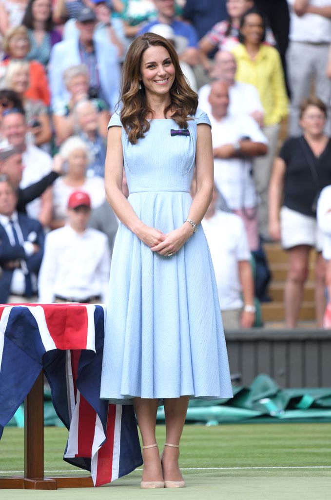 Kate sur un court de tennis en robe bleu pâle