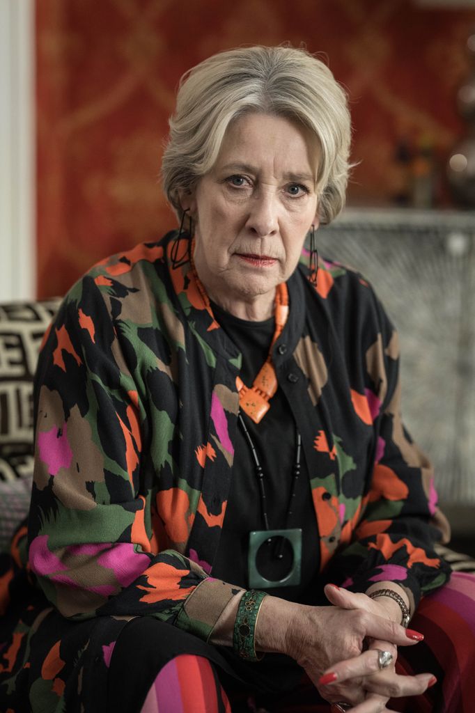 woman dressed in colourful jacket sitting on chair