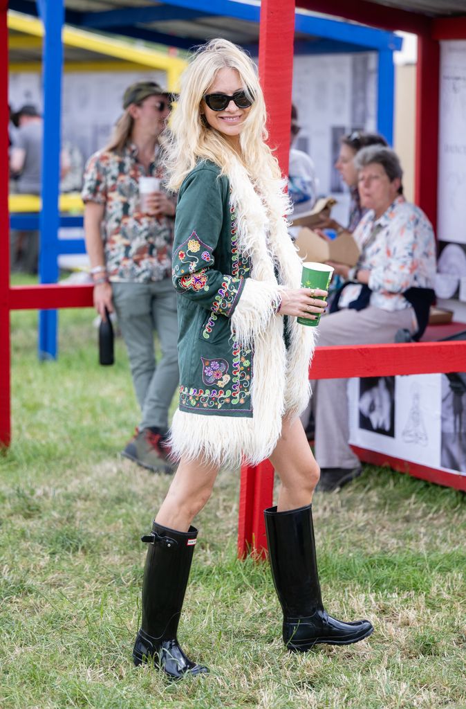 oppy Delevingne attends day three of Glastonbury Festival at Worthy Farm, Pilton on June 24, 2022 in wellington boots and a fluffy fringed coat