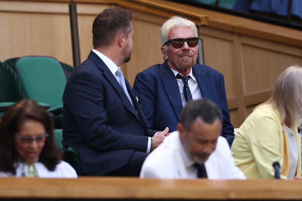 Richard Branson (R) sits in the Royal Box in suit