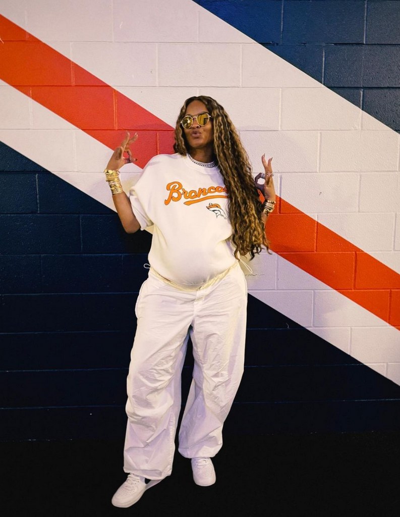 Photo shared by Ciara on Instagram October 2023 where she is posing in a Broncos sweatshirt showing off her baby bump.