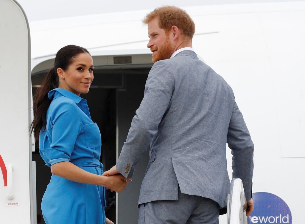 Prince Harry, Duke of Sussex and Meghan, Duchess of Sussex walk together, ahead of Tonga's Princess Angelika, as they depart from Fua'amotu International Airport on October 26, 2018 in Fua'amotu, Tonga.