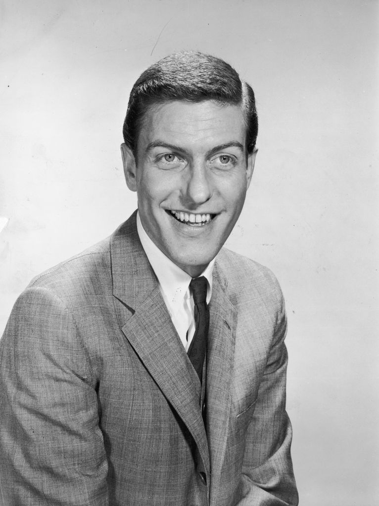 1958:  Portrait of American comedian and actor Dick van Dyke smiling in a suit and tie.