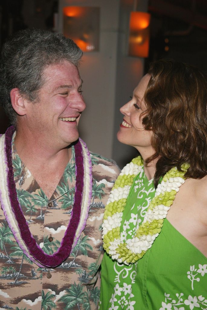 sigourney weaver and husband jim simpson smiling at each other