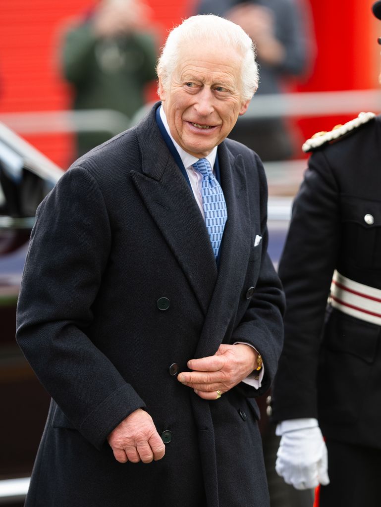 charles walking in coat and blue tie