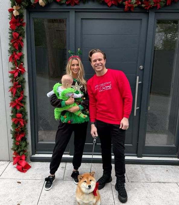 Amelia Tank holding a baby and standing with Olly Murs outside their home