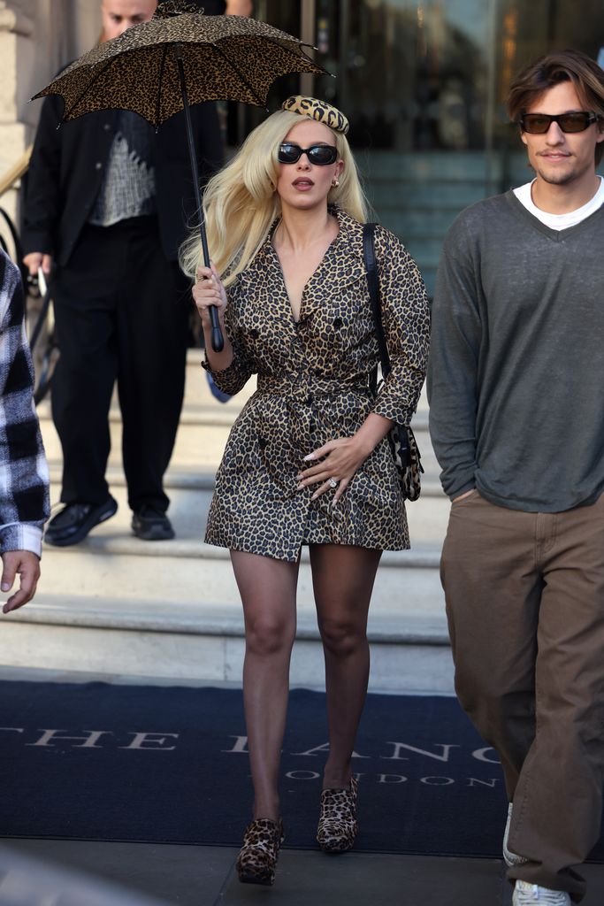 Millie Bobby Brown in leopard print coat and Jake Bongiovi in gray jumper leaving The Langham Hotel 