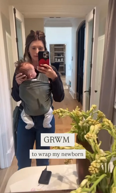Katherine Schwarzenegger taking a mirror selfie with her baby son, Ford, wrapped in a sling around her body