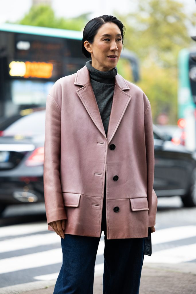 Eva Chen mengenakan sweter turtleneck hijau tentara, blazer oversized merah muda, dan jeans lebar kaki biru menjelang pertunjukan Chloé selama Pakaian Wanita Musim Semi/Musim Panas 2025 selama Paris Fashion Week pada 26 September 2024 di Paris, Prancis. 