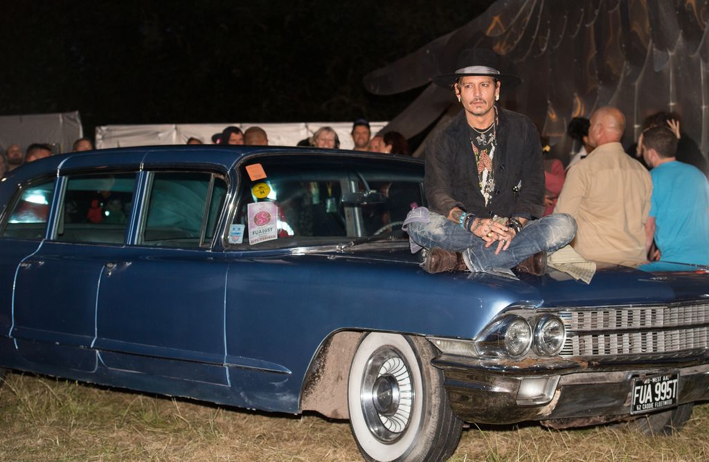 Johnny Depp sitting on a car
