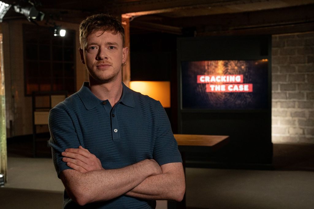 A man with his arms crossed wears a blue shirt 
