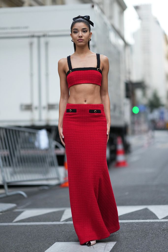PARIS, FRANCE - SEPTEMBER 29: A guest wears a ribbon over the hair, a black and red crop top / bras made of tweed, a long tweed skirt, outside Alessandra Rich, during the Womenswear Spring/Summer 2024 as part of  Paris Fashion Week on September 29, 2023 in Paris, France. (Photo by Edward Berthelot/Getty Images)