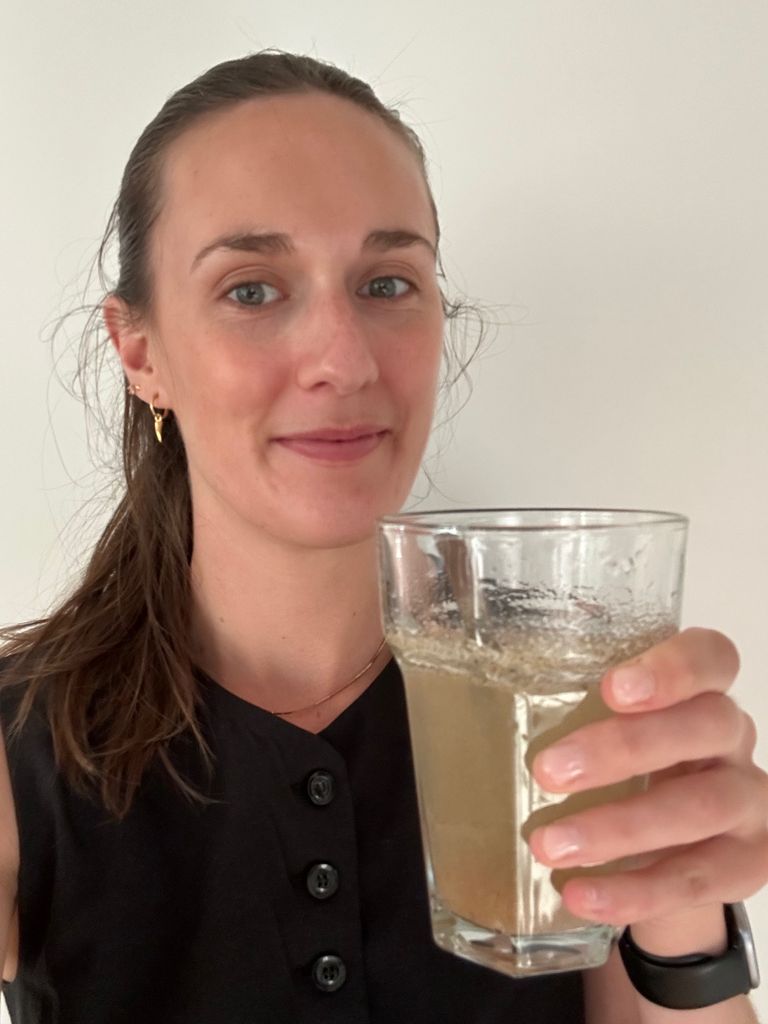 Woman holding a glass with liquid in it 