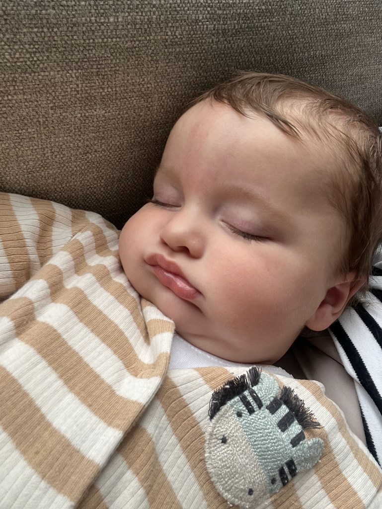 sleeping baby with striped babygrow on 