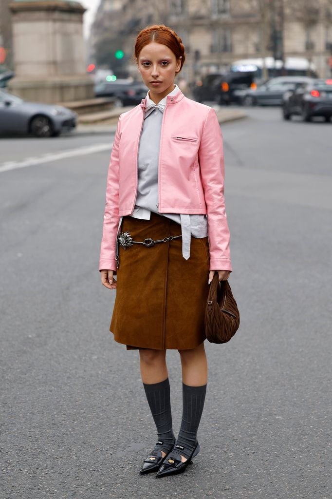 PARIS, FRANCE - MARCH 11: Marie Gaguech wears white shirt, grey jumper, pink Miu Miu jacket, brown suede midi skirt, silver belt, brown Miu Miu bag, grey Miu Miu socks, black Miu Miu kitten heels, outside Miu Miu, during the Womenswear Fall/Winter 2025/2026 as part of Paris Fashion Week on March 11, 2025 in Paris, France. (Photo by Claudio Lavenia/Getty Images)Marie Gaguech wears white shirt, grey jumper, pink Miu Miu jacket, brown suede midi skirt, silver belt, brown Miu Miu bag, grey Miu Miu socks, black Miu Miu kitten heels, outside Miu Miu, during the Womenswear Fall/Winter 2025/2026 as part of Paris Fashion Week 