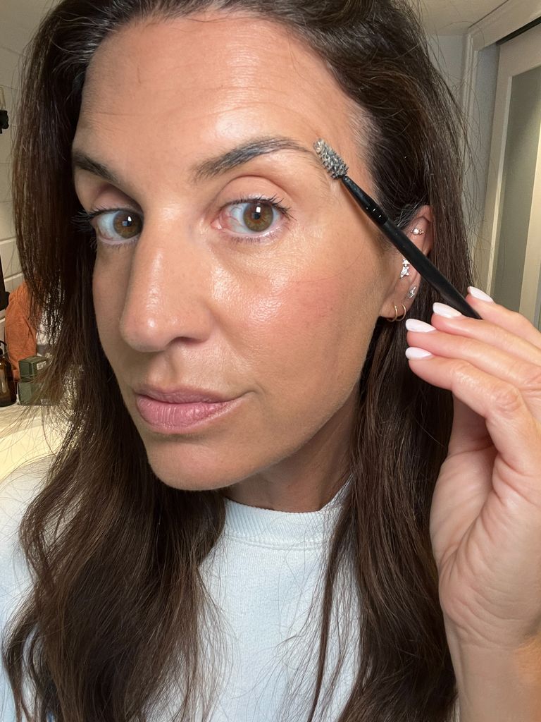brunette woman applying brow gel