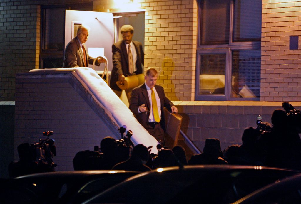 FBI agents, with television photographers waiting for them, walk out of an apartment building at 170 Gore Street in Cambridge carrying evidence they collected from the apartment of James Lewis