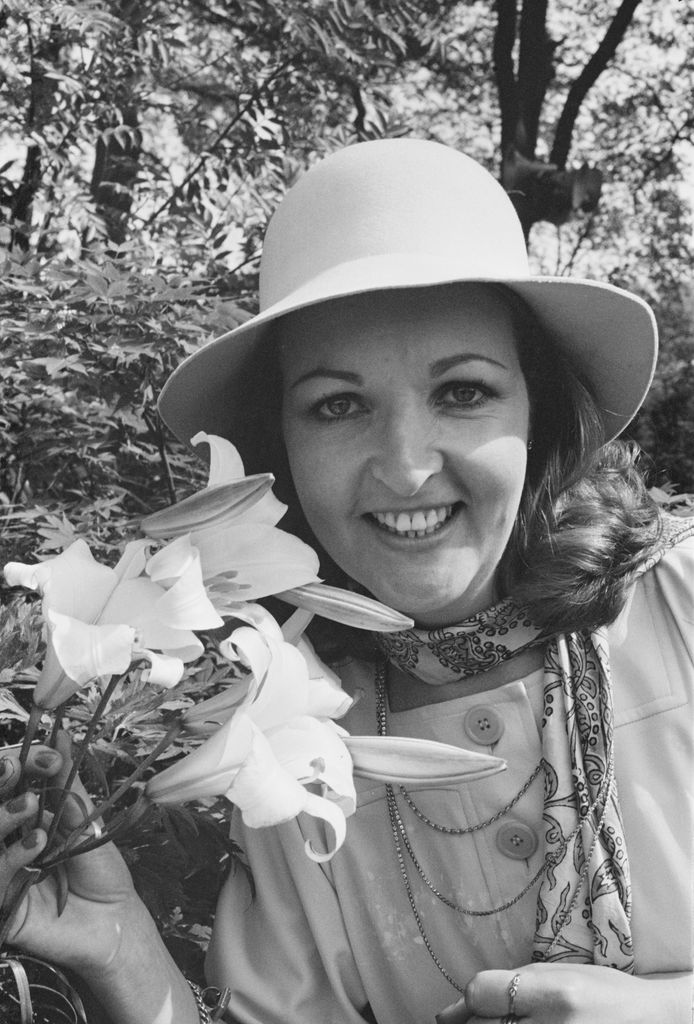 woman smiling next to lily stem