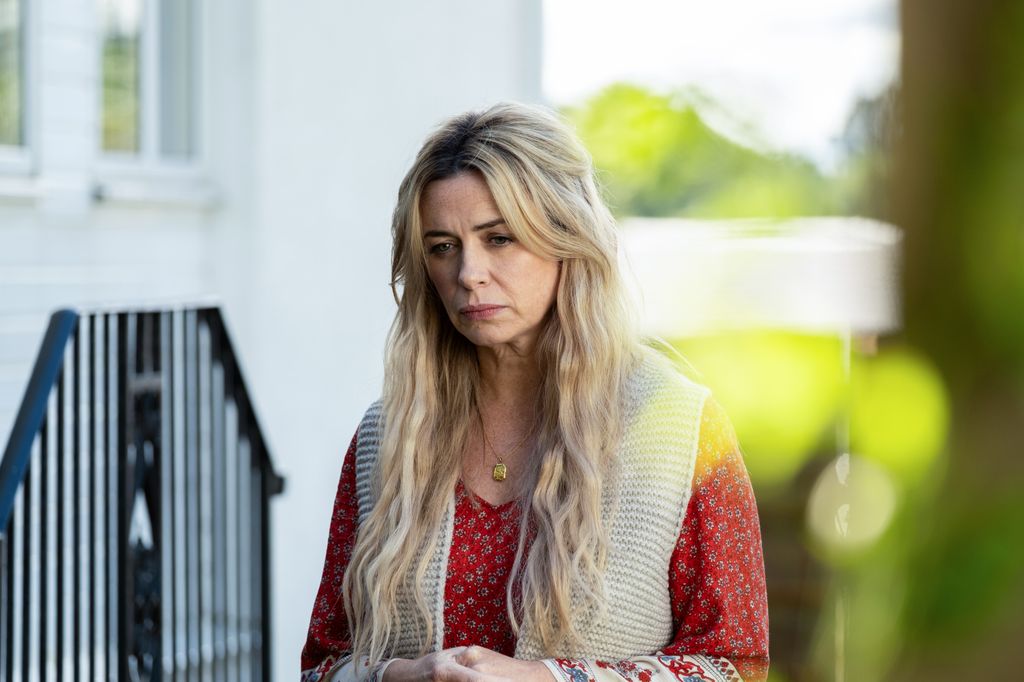 blonde woman standing outside house
