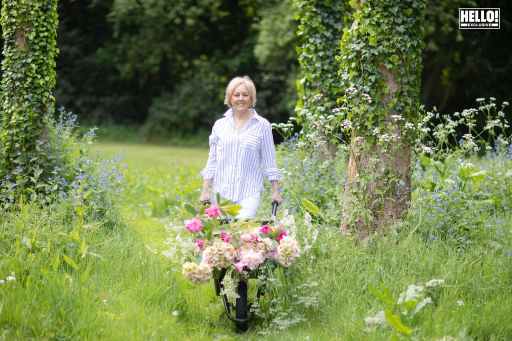 Shirlie Kemp wheelbarrows blooming flowers in her garden