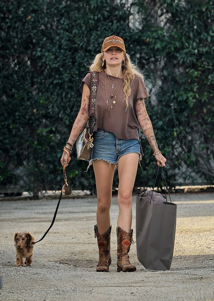 Paris Jackson in denim shorts and brown top and cowboy boots