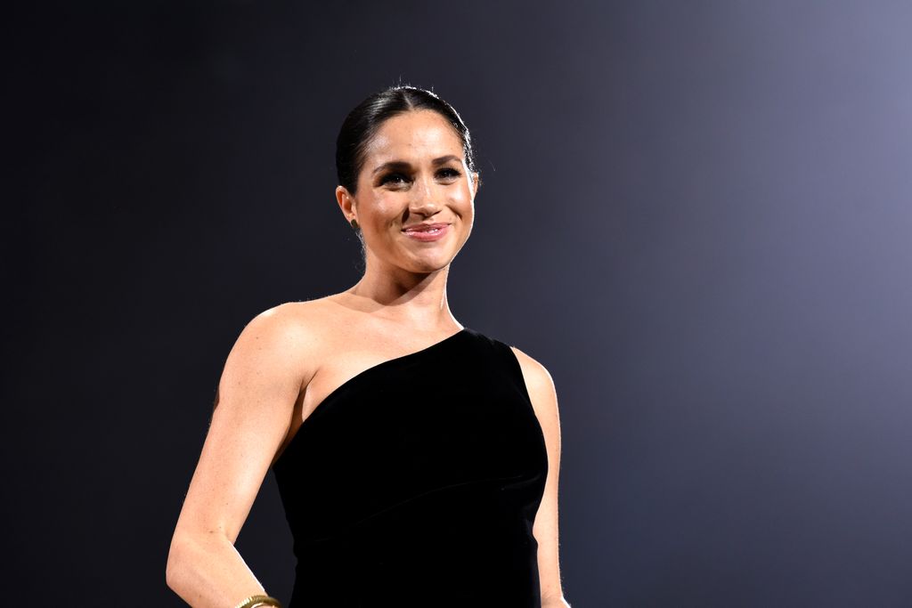 Meghan Markle wearing a black one-shoulder dress