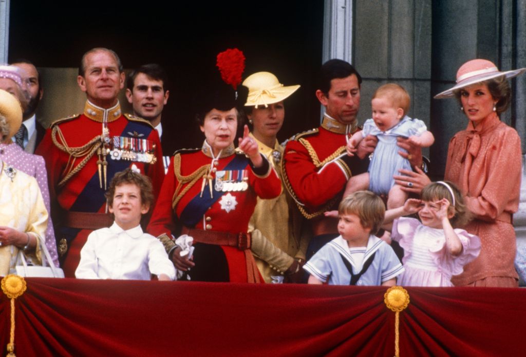 Prince Charles holding Prince Harry on palace balcony