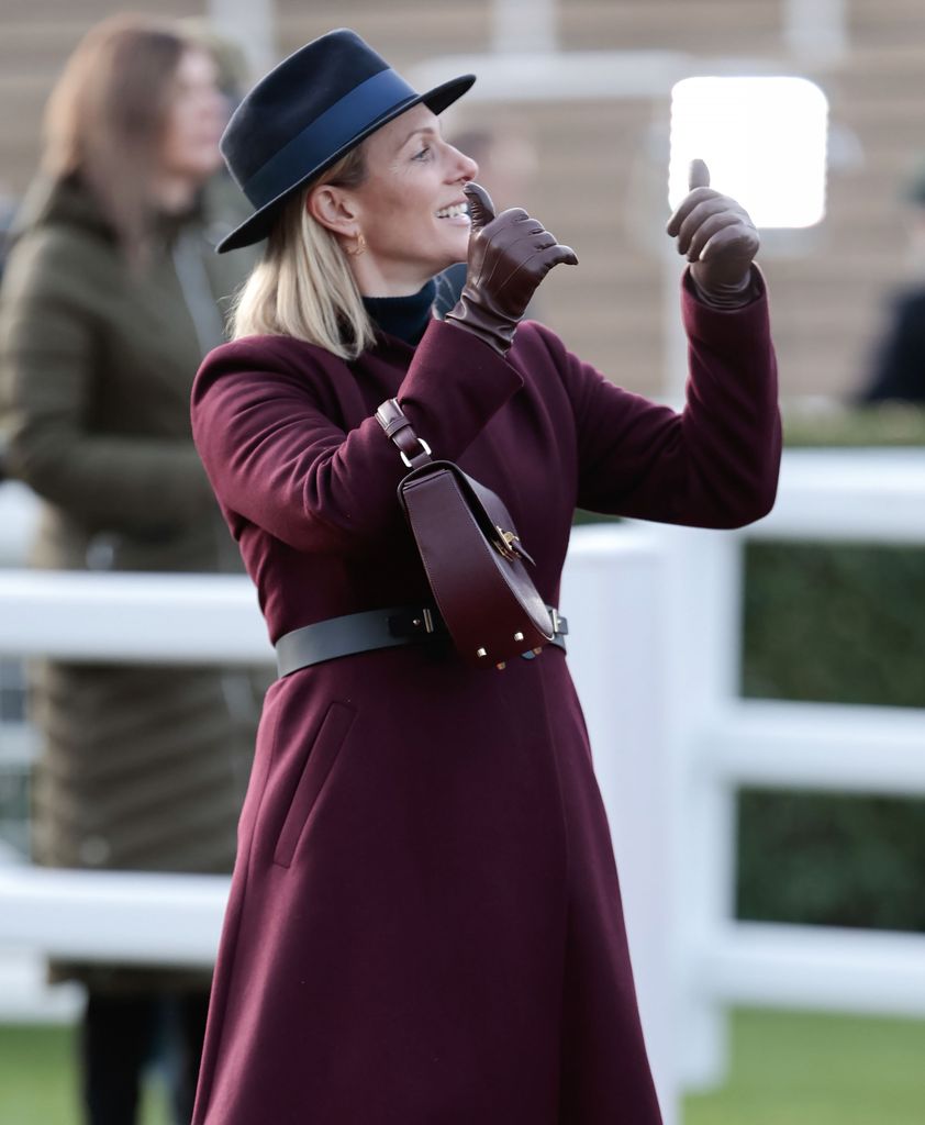 Zara Tindall in a maroon coat giving a thumbs up