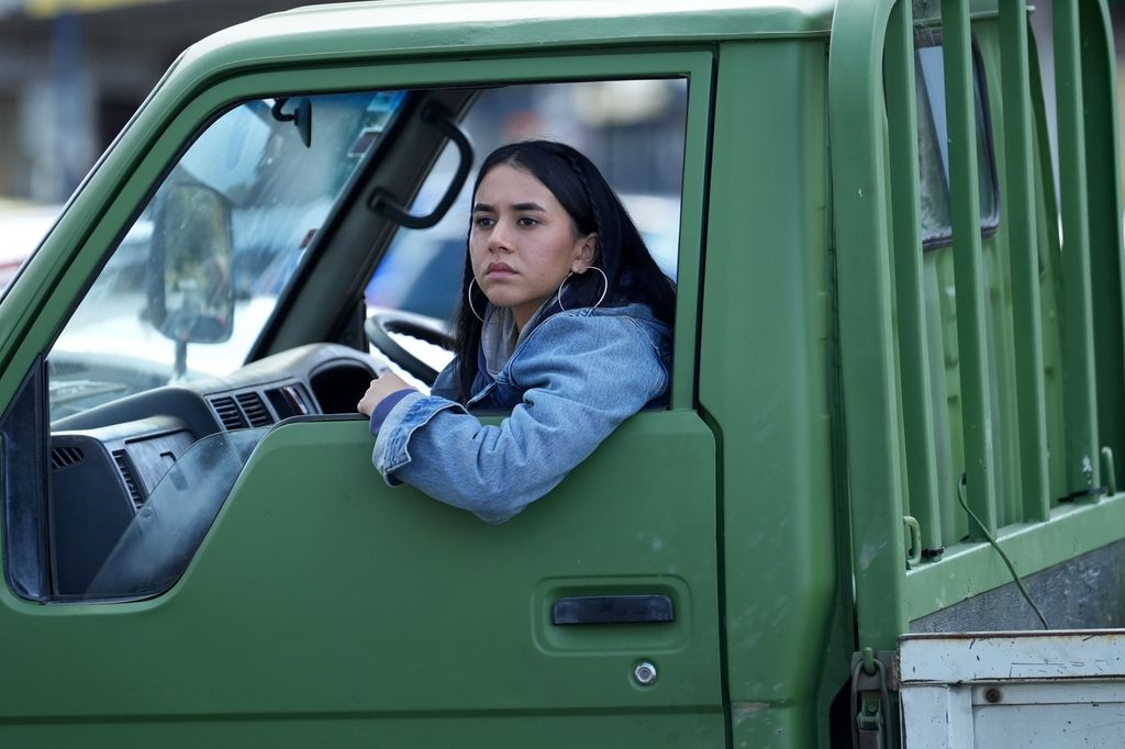 woman in driver's seat of green car