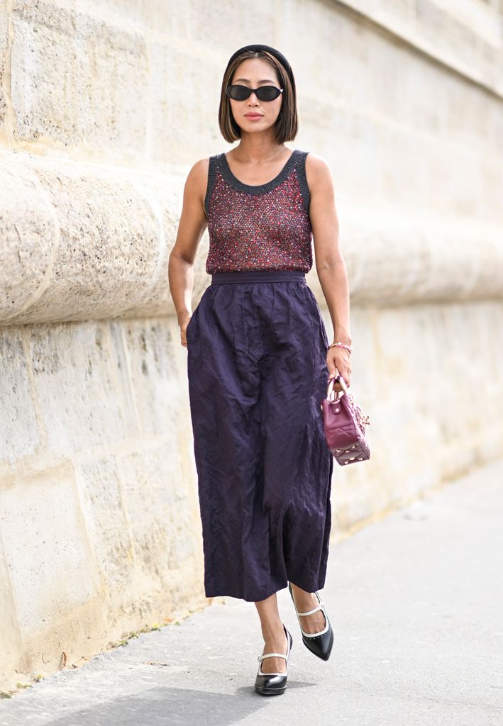 Aimee Song is seen wearing a Dior sleeveless top, Dior purple skirt, black and white shoes and black sunglasses with a purple Dior bag outside the Dior show during the Womenswear Spring/Summer 2024 as part of Paris Fashion Week on September 26, 2023 in Paris, France. (Photo by Daniel Zuchnik/Getty Images)