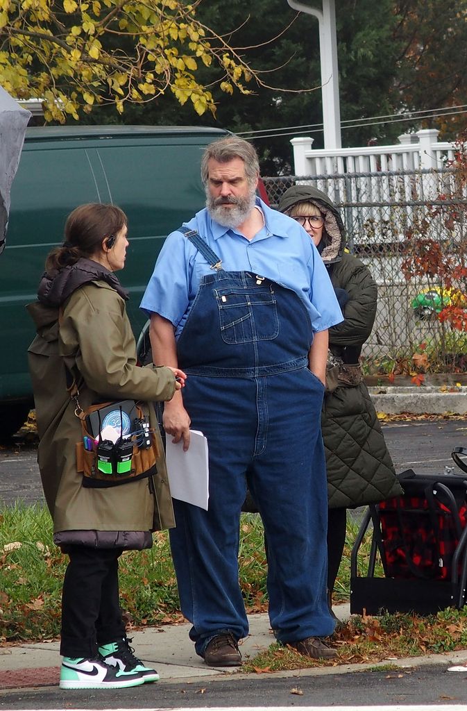 photo of david harbour with grey beard and padded suit wearing overalls