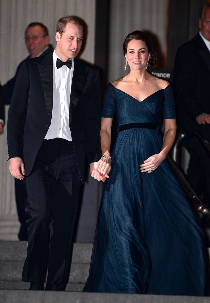 La princesse Kate enceinte en robe bleu foncé tient la main de William