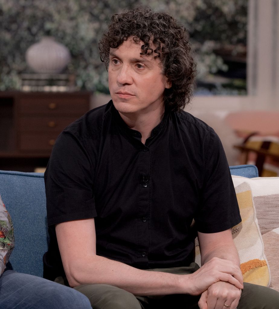 Man in black shirt sitting on sofar