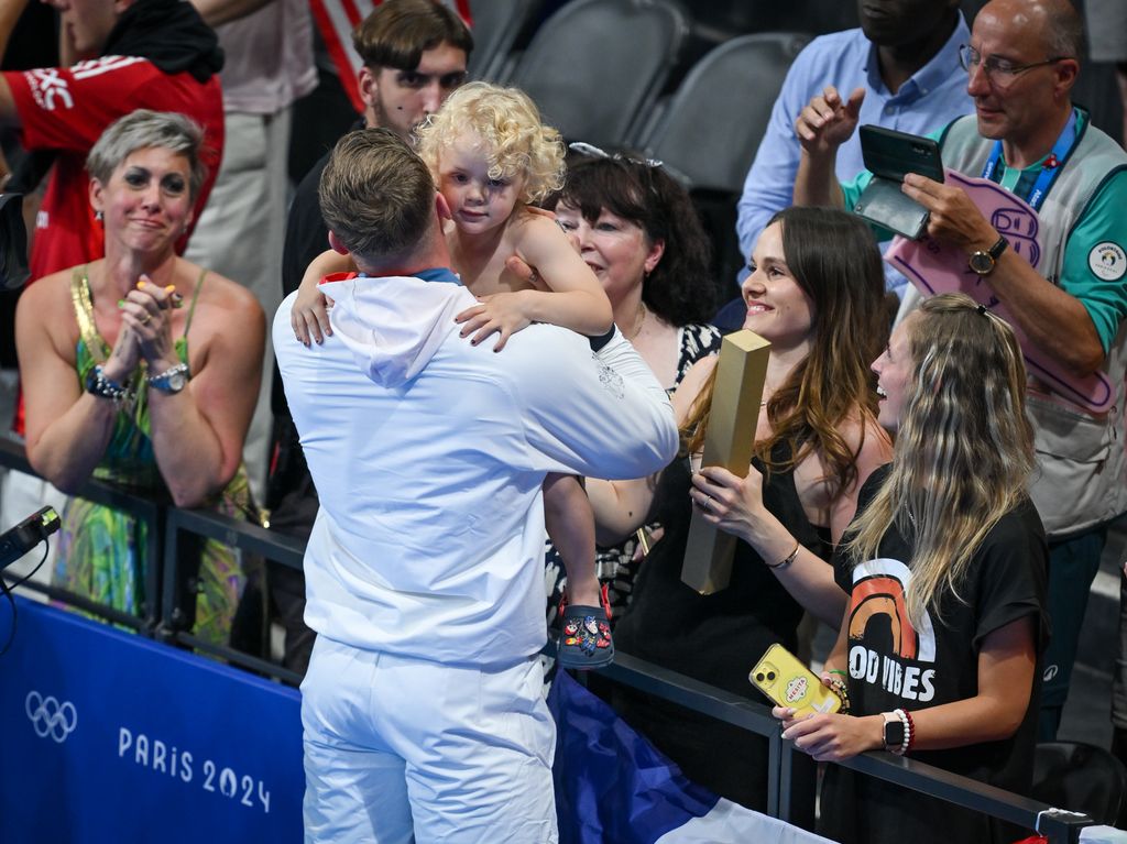 Adam Peaty cuddling his baby George