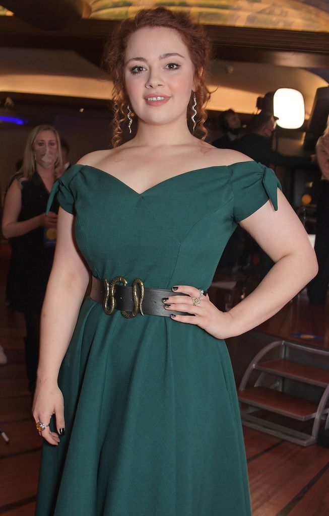 Carrie Hope Fletcher in a green off-the-shoulder dress with her hair up