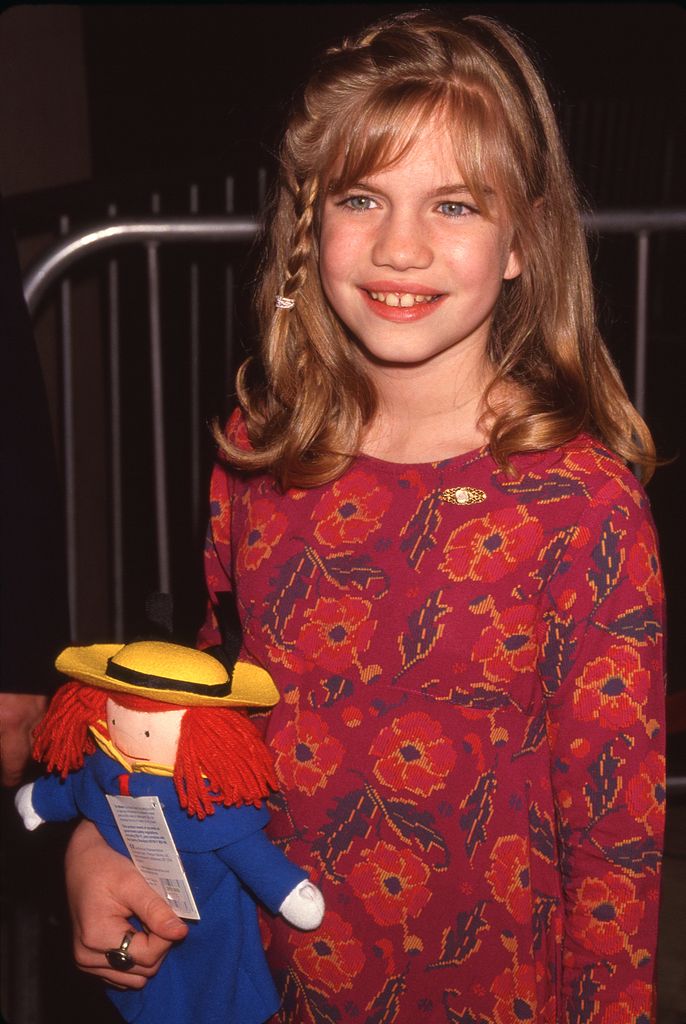 Anna smiling with braid and carrying a doll
