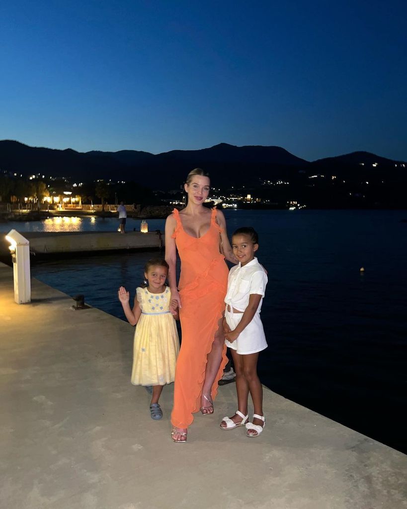 Helen Flanigan wearing orange dress with kids on holiday