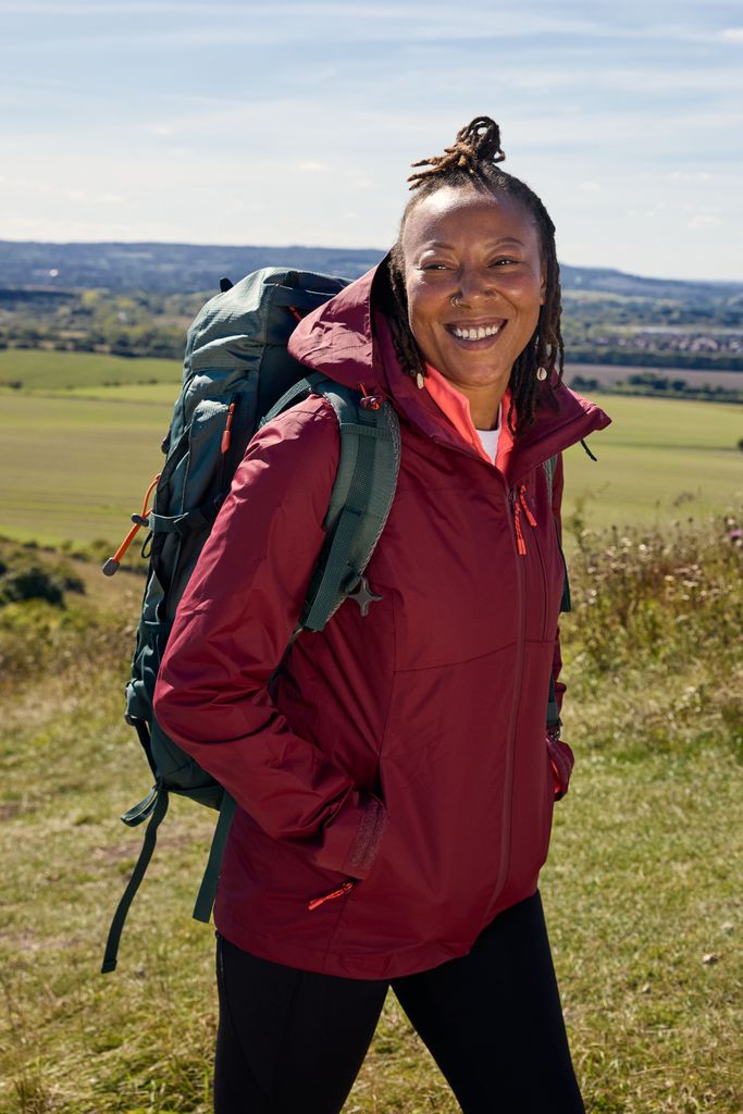 black woman smiling in a burgundy raincoat