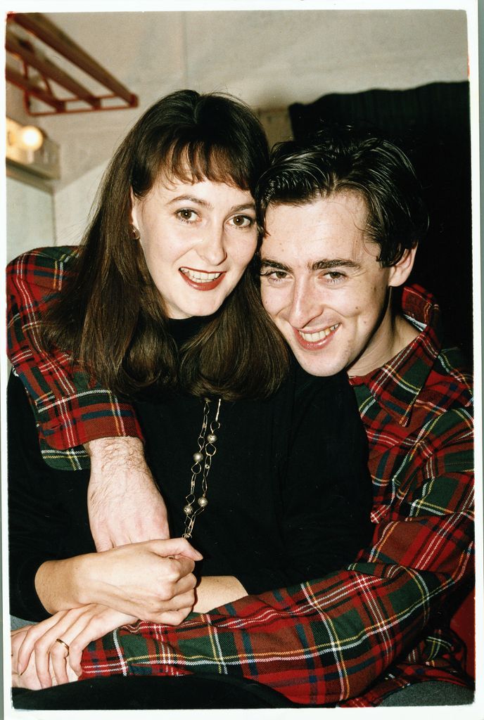 Alan Cumming with his arm around Hilary Lyon