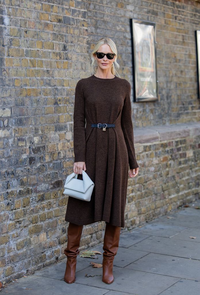 Poppy Delevingne wears brown belted dress with long sleeves, grey bag, brown boots outside JW Anderson during London Fashion Week September 2023 