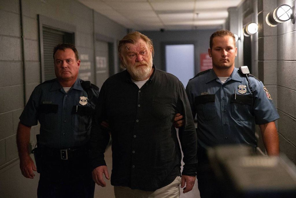 man escorted down corrider by two officers in uniform