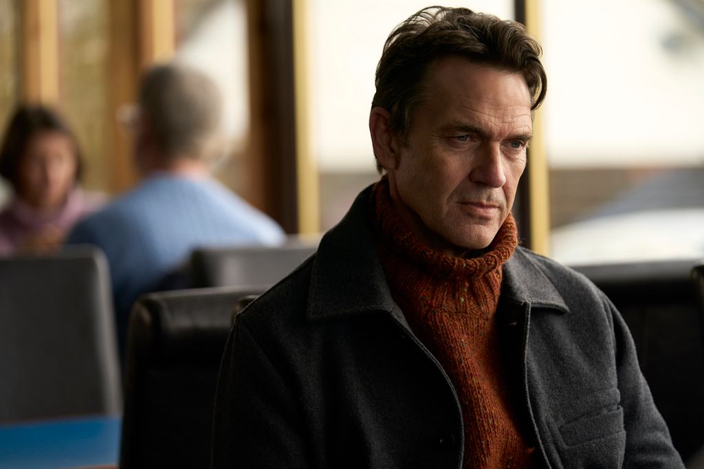 man in coat sitting in cafe