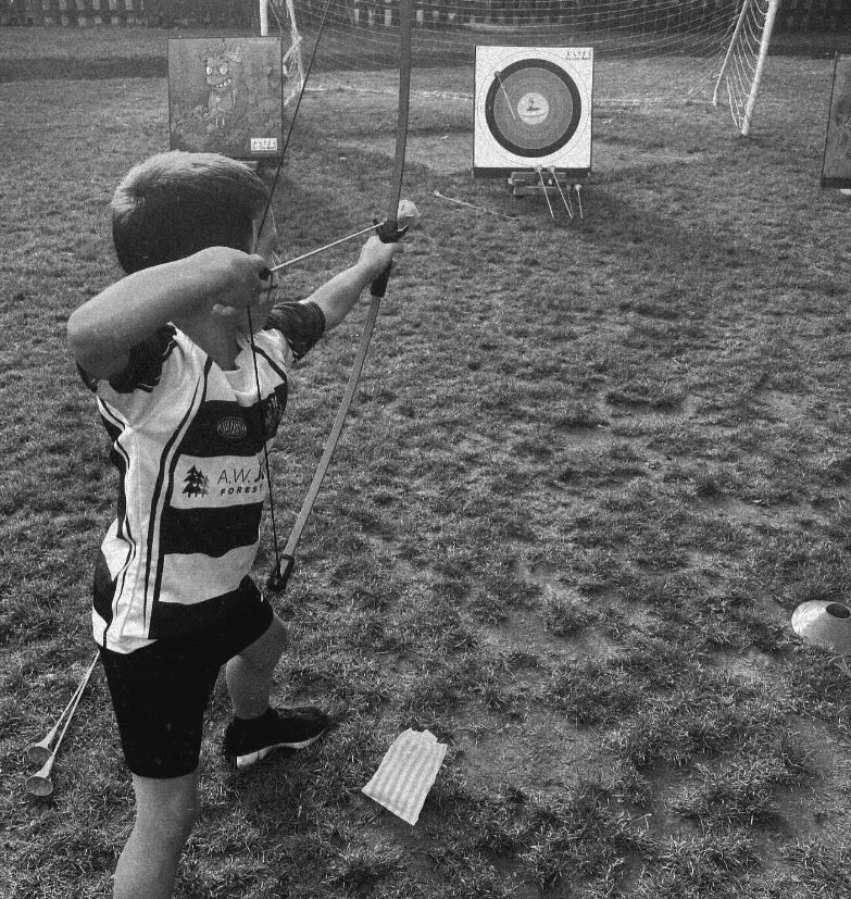 A young boy shooting an arrow at a target