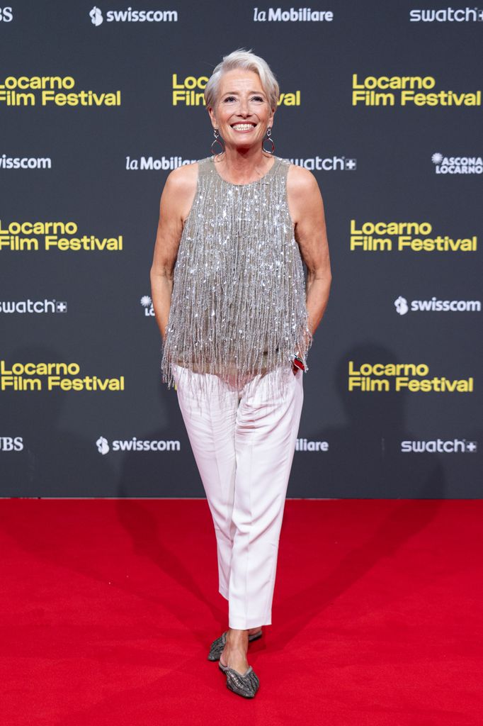 Emma Thompson on red carpet in white trousers and sparkly top