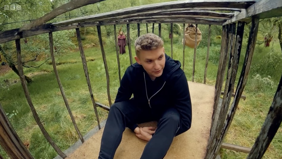 Reece in a cage during a challenge on The Traitors
