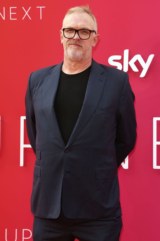 Gret Davies in a grey suit and black shirt