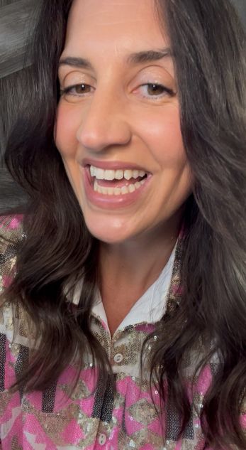 Brunette woman smiling widely for a selfie 