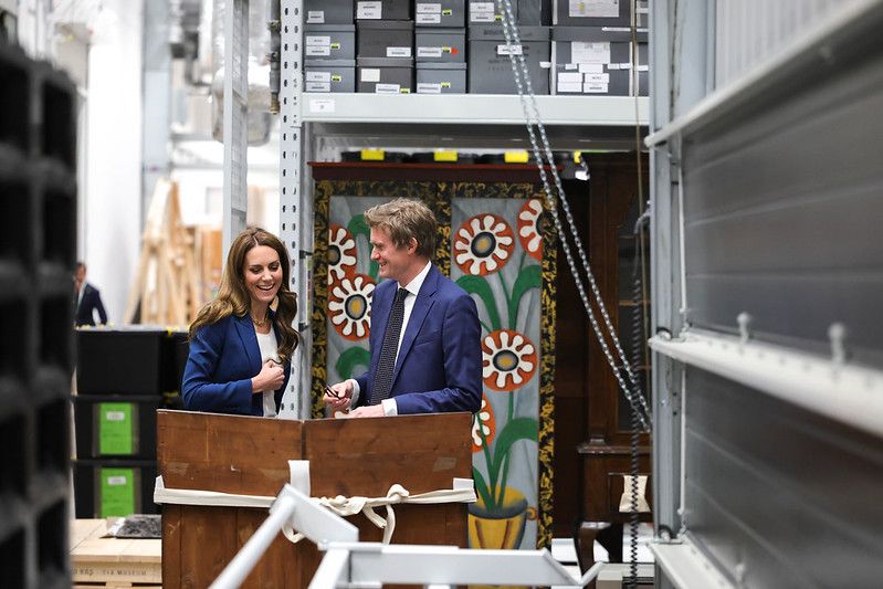 princess kate in blue suit looking at item from V&A storehouse