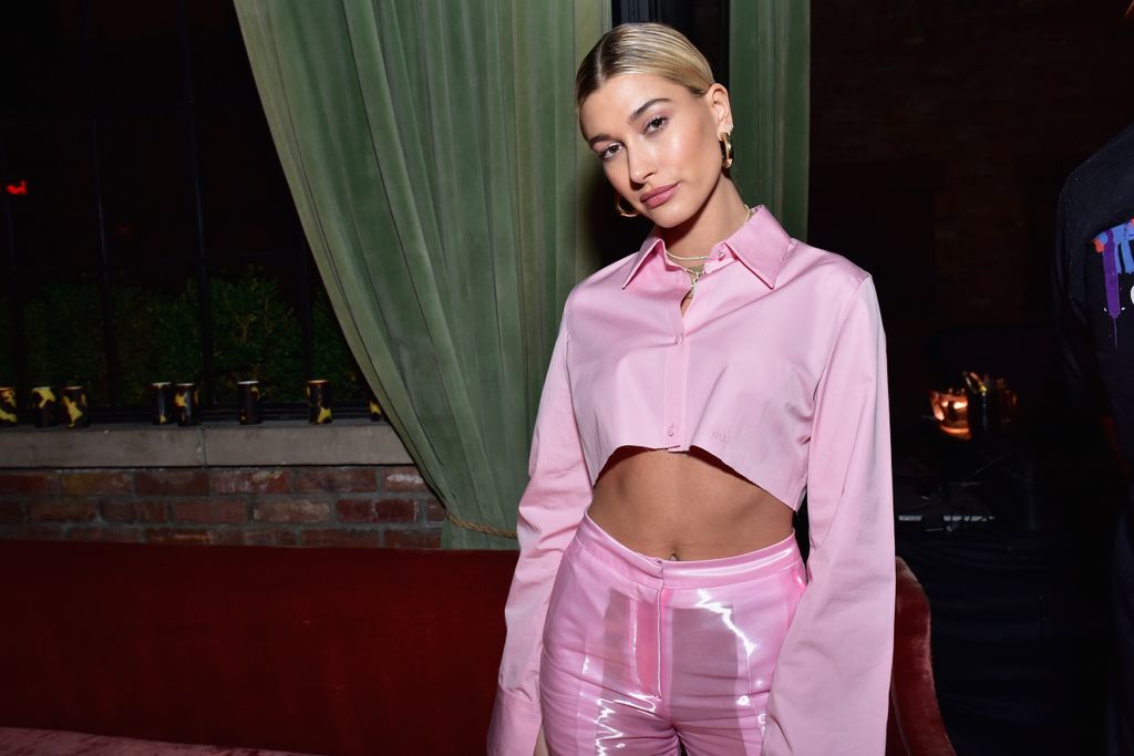 Hailey wearing a cropped pink suit 